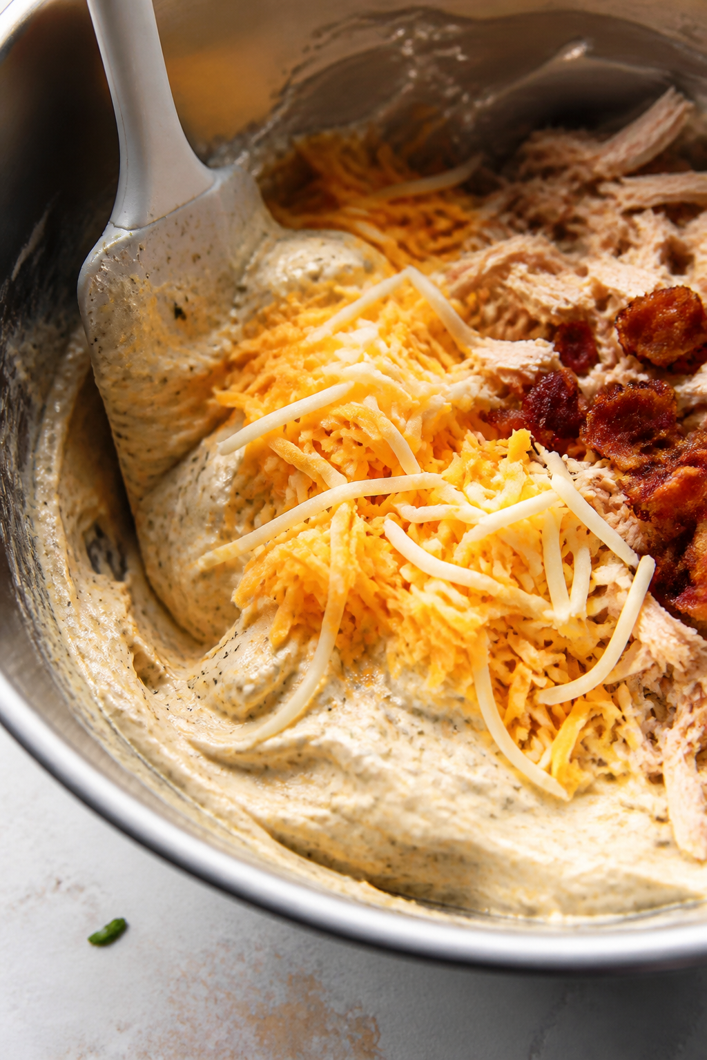 Cooking process, close-up detail: Close-up of the creamy base being folded together in a stainless m
