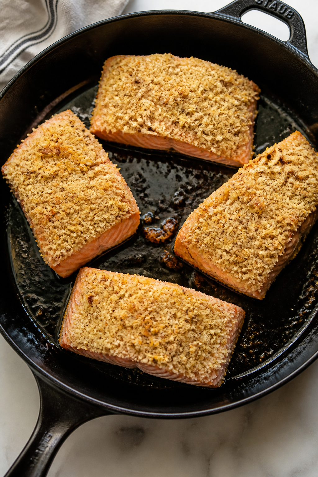 Cooking process: Salmon fillets in an oven-safe skillet just after stovetop sear and topping—flesh
