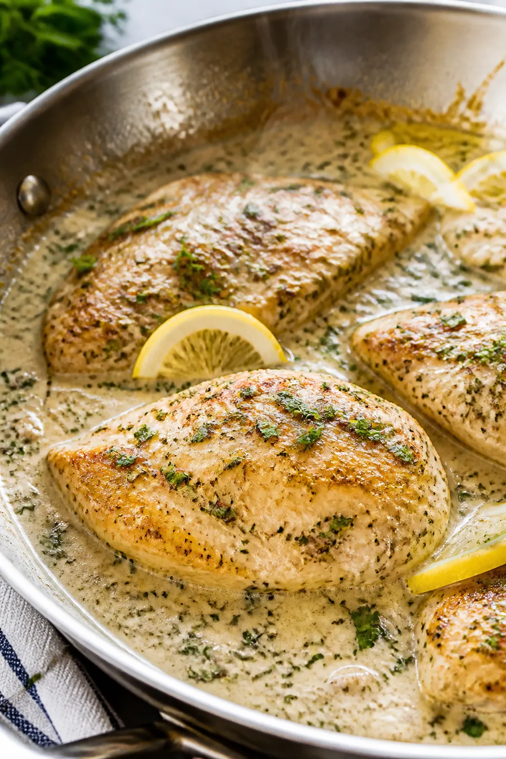 Close-up detail: Golden-seared chicken breasts nestled in a silky creamy ranch sauce in a stainless-